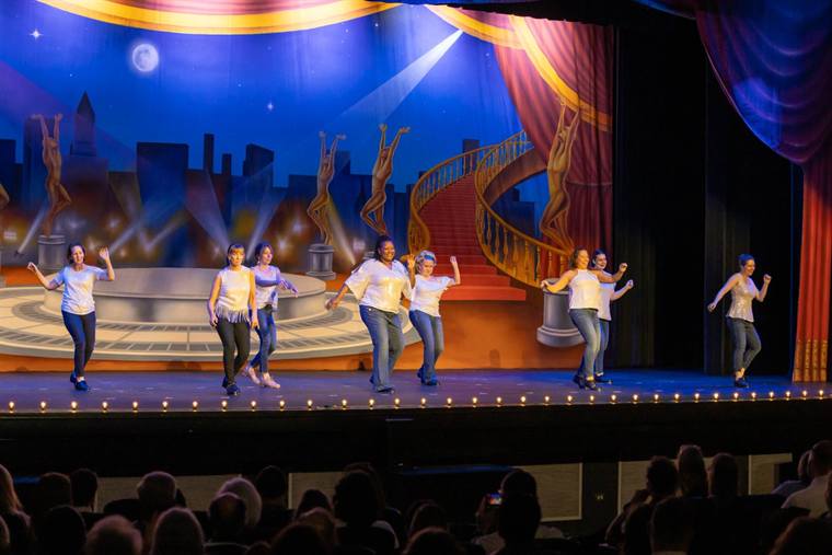 Adult tap students performing together on stage