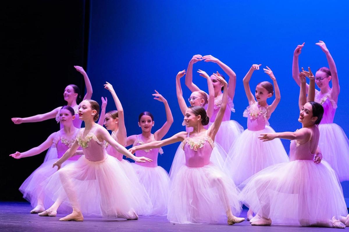 Young dancers in pink tutus performing together on stage
