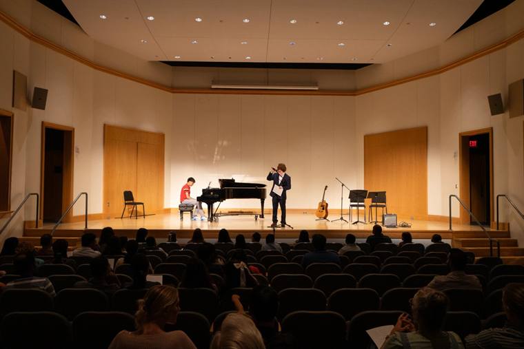 Audience seated in a concert hall watching performers on stage