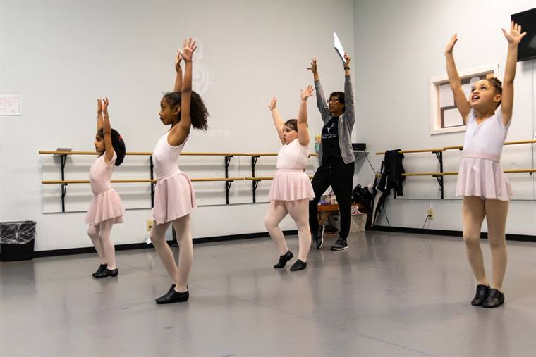 Young ballet students working at the barre during class